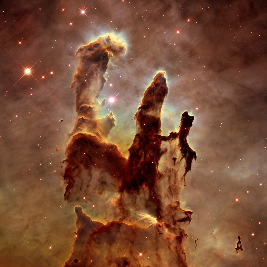 A detailed space photograph of towering columns of gas and dust within a nebula, with bright stars forming nearby