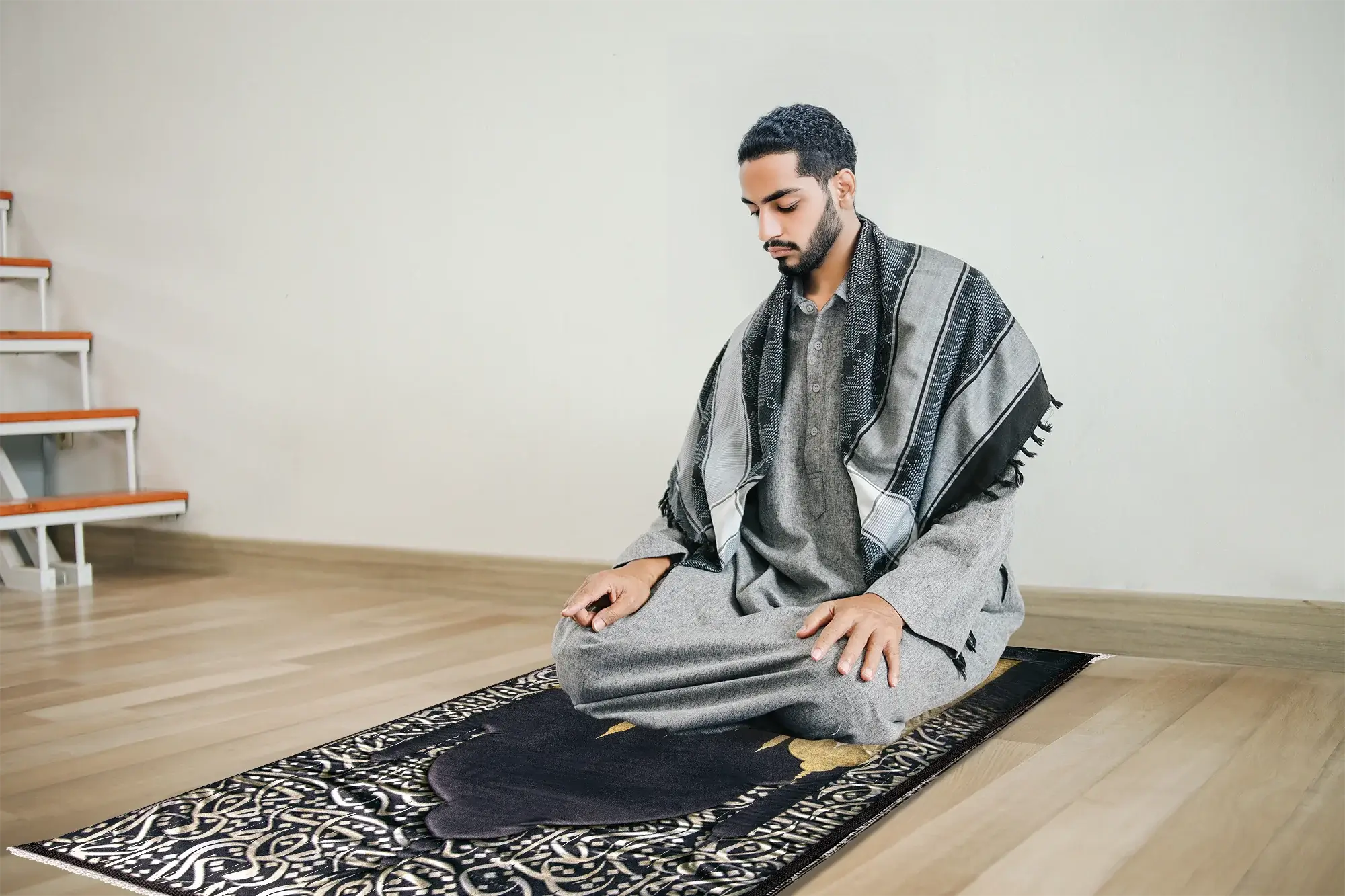 A person kneeling in prayer on a simple prayer rug in a quiet living room with soft morning light coming through a window
