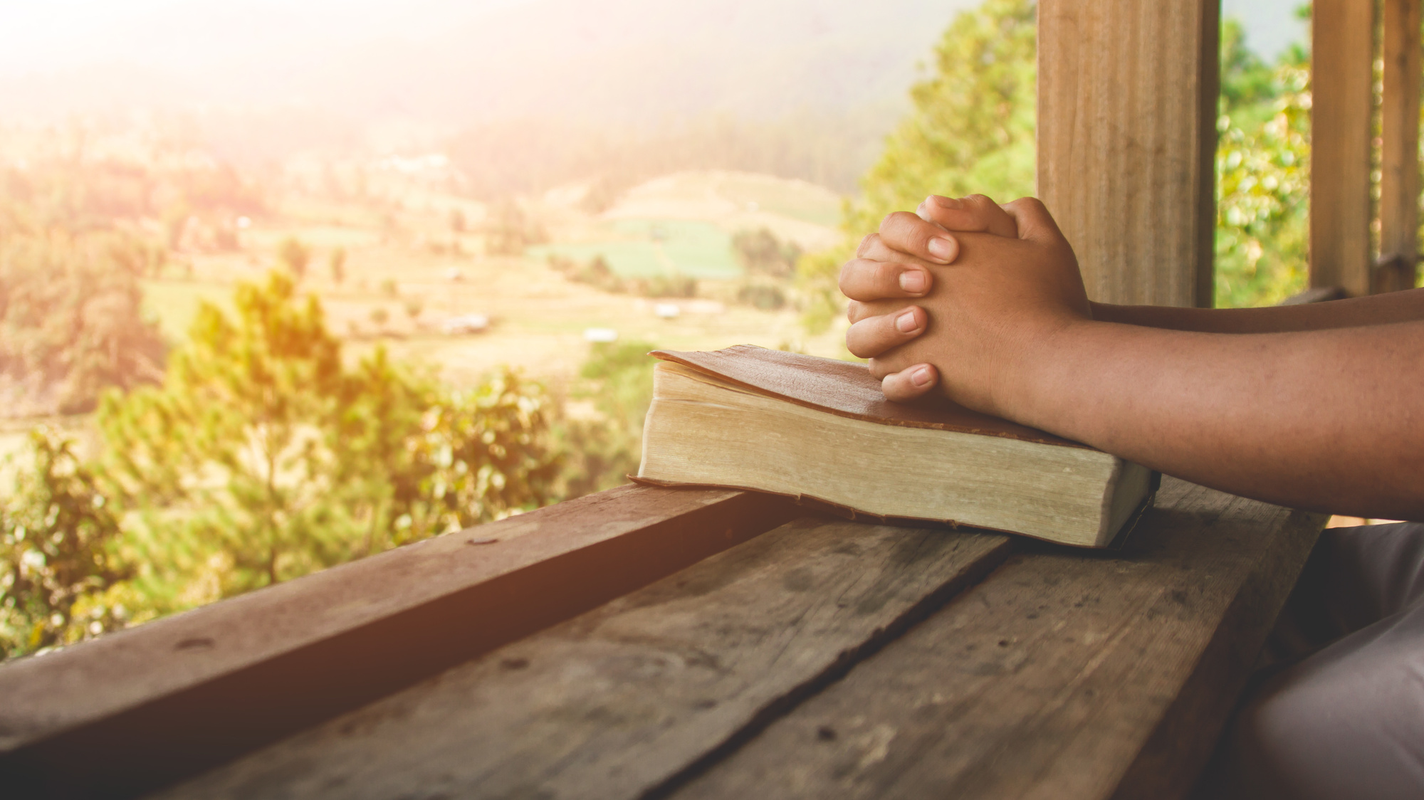 A quiet morning scene with a mug of coffee beside an open sacred book on a small table near a window