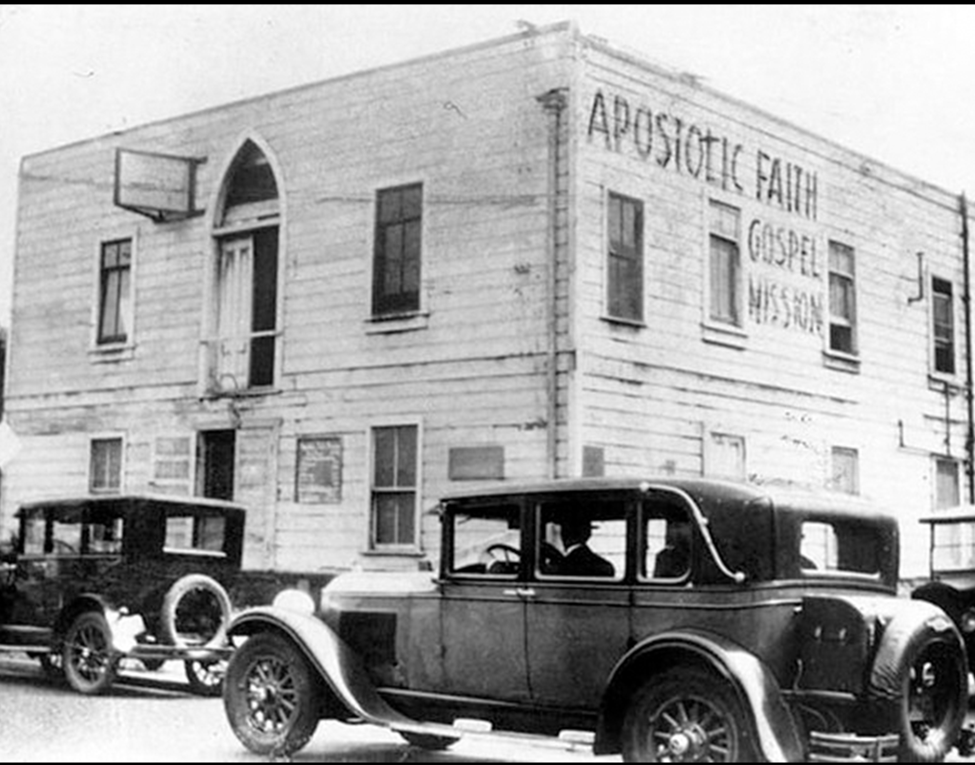 A street view of a building associated with the Azusa Street Revival in Los Angeles as pedestrians walk past