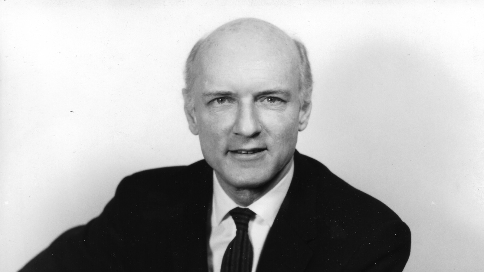 Heinz von Foerster speaking at a university podium in a mid-20th-century academic setting.